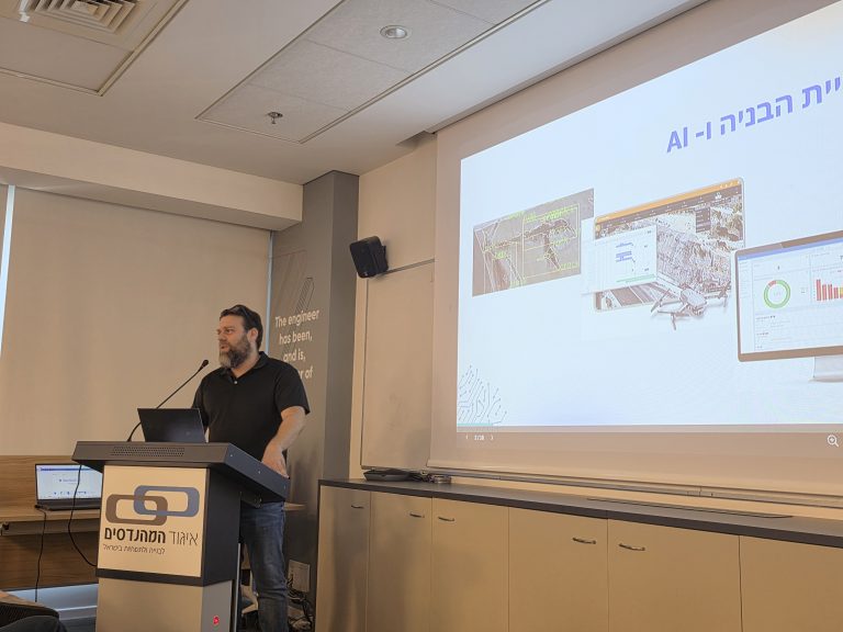 מר תומר יעקב עומד ומרצה מול קהל: איך להפוך את הבינה המלאכותית מטרנד מפחיד למנוע צמיחה חכם